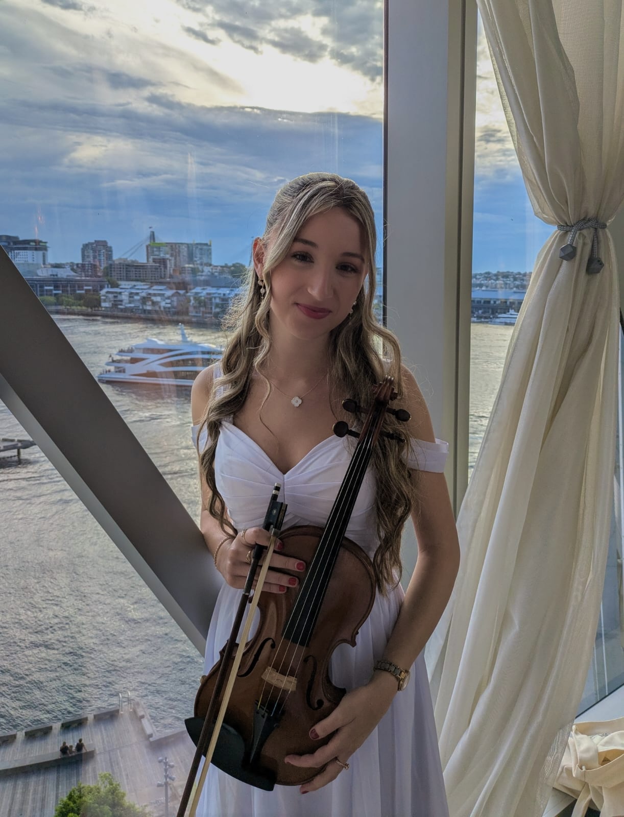 Tali in white dress holding violin